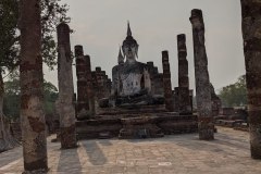 Figure sitting among the ruins in the sunlight, Sukhothai